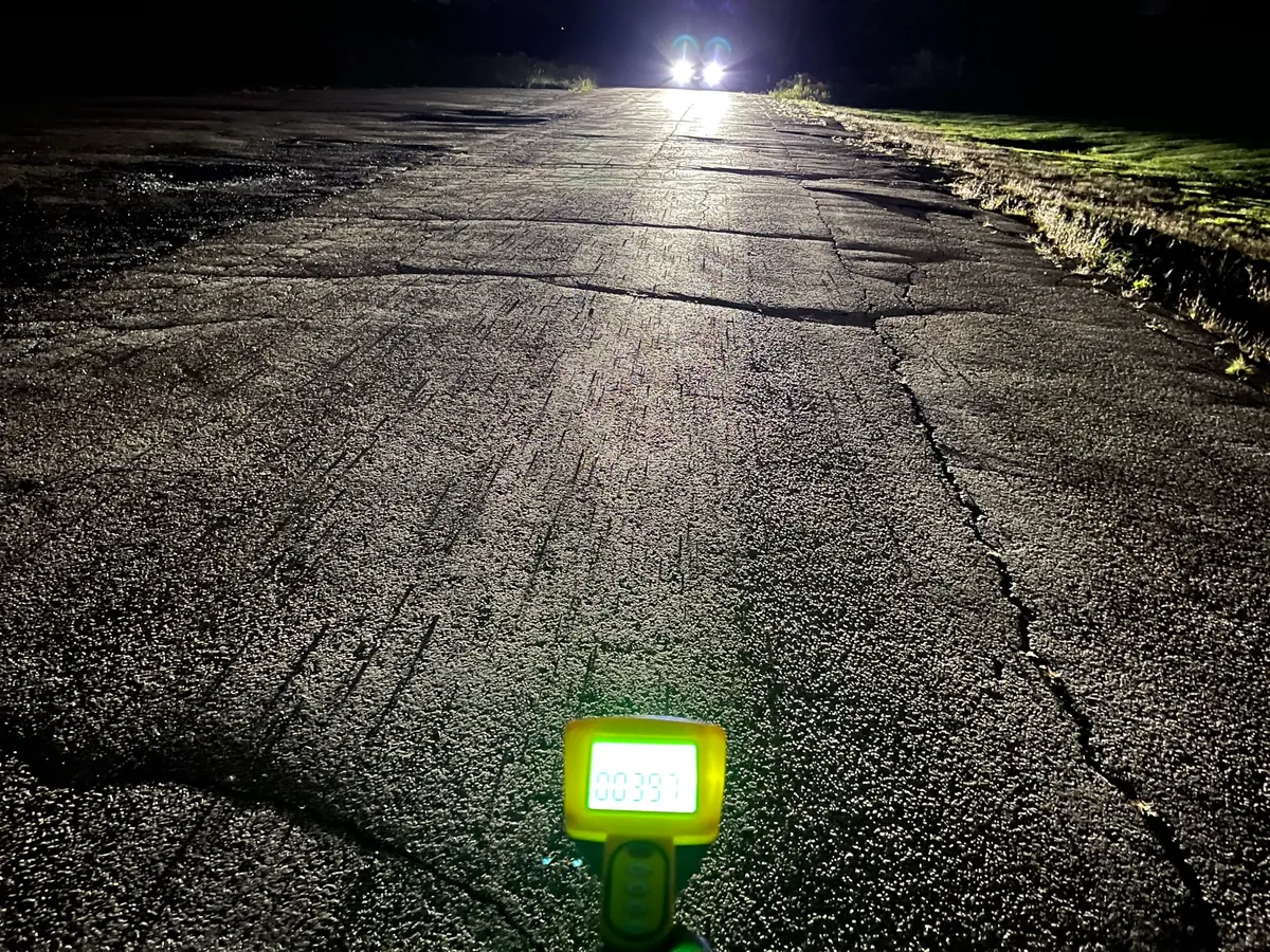 BulbFacts measuring headlight illumination on a dark road with a lux meter